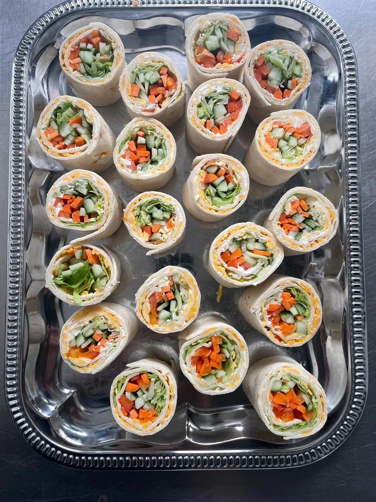 Tortillové závitky nakrájené na kolečka, uvnitř zelenina a smetanový sýr